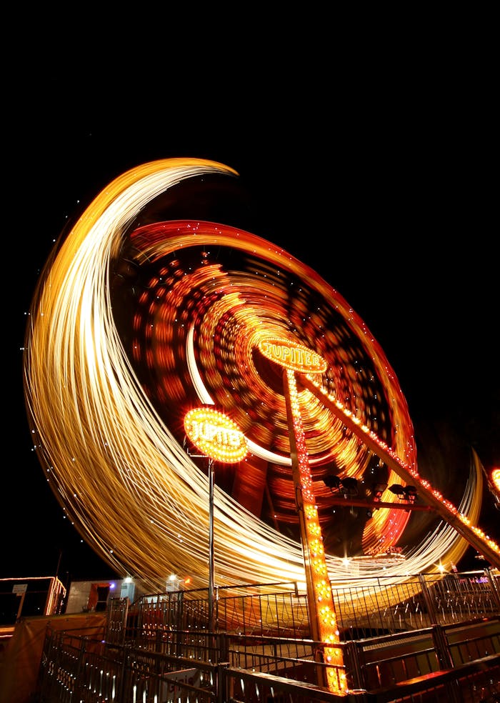 A vibrant long exposure photo capturing the motion and lights of a Ferris wheel at night.